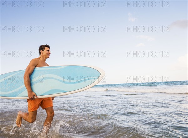 Young man carrying surfboard. Jupiter, Florida, USA.
Photo : Daniel Grill