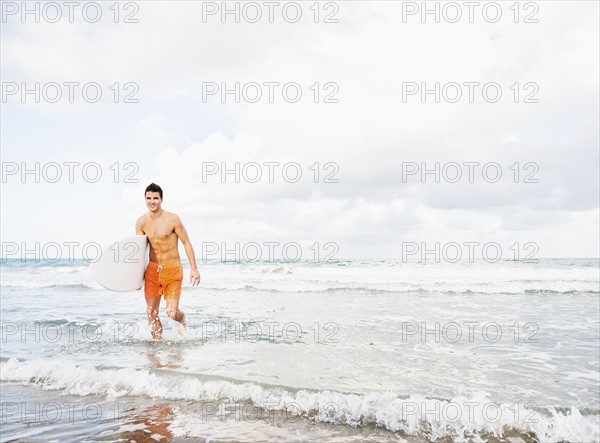 Young man carrying surfboard. Jupiter, Florida, USA.
Photo : Daniel Grill