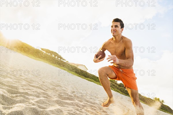 Young man playing football on beach. Jupiter, Florida, USA.
Photo : Daniel Grill