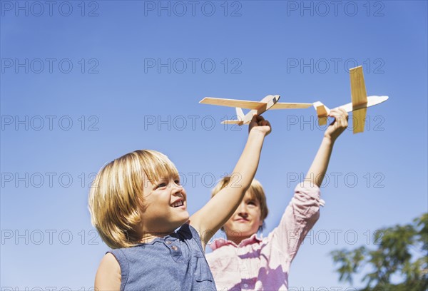 Boys (4-5, 8-9) playing with airplane toys.
Photo : Daniel Grill