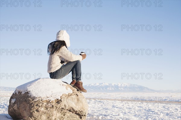 Woman sitting on rock with cup in winter. Colorado, USA.
Photo : Maisie Paterson