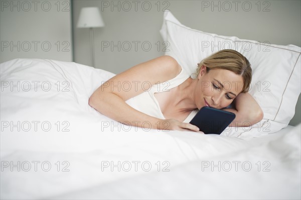 Woman with digital tablet in bed.
Photo : Mark de Leeuw