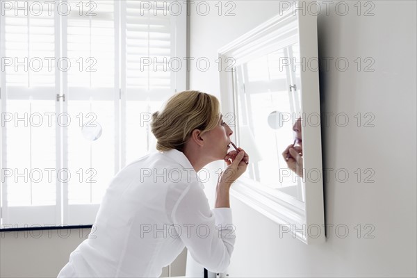 Woman applying make-up.
Photo : Mark de Leeuw