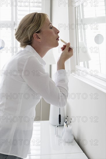 Woman applying make-up.
Photo : Mark de Leeuw