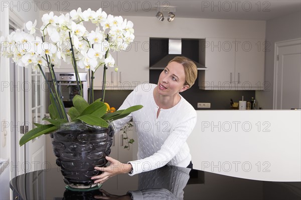 Woman putting orchid on table.
Photo : Mark de Leeuw
