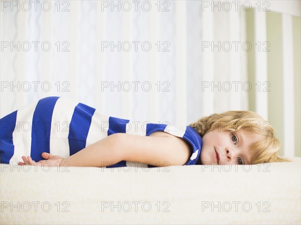 Girl (4-5) resting on bed.
Photo : Jessica Peterson