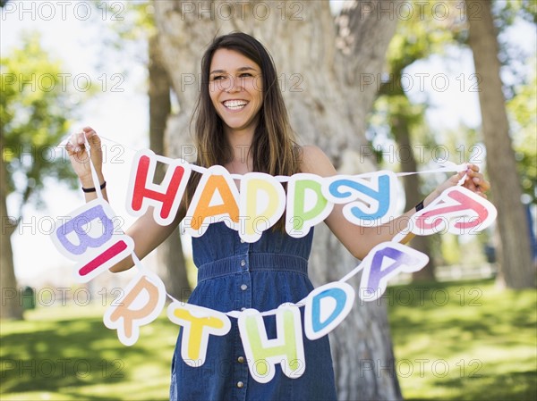 Young woman holding Happy birthday banner. Salt Lake City, Utah, USA.
Photo : Jessica Peterson