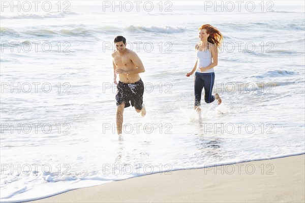 Couple running on beach.