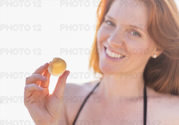 Portrait of woman holding shell.