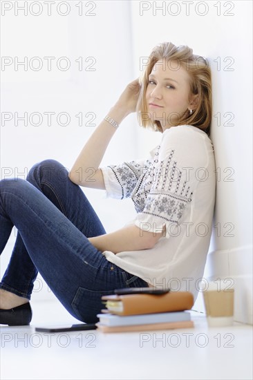 Portrait of young woman sitting on floor.