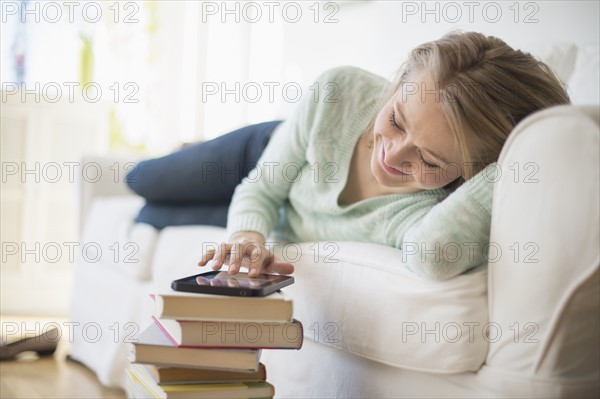 Woman lying on sofa and using digital tablet.