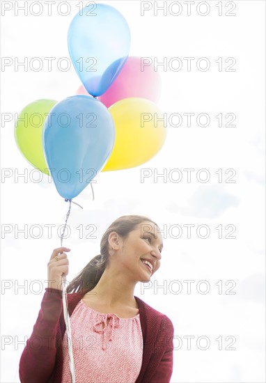 Young woman with colorful balloons.