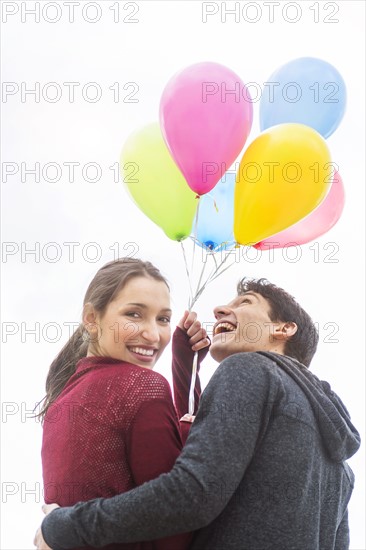 Young couple with balloons.