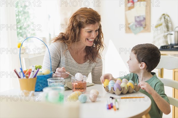 Mother and son (6-7) painting Easter eggs.