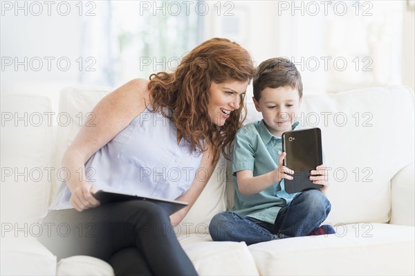 Mother and son (6-7) using digital tablet.