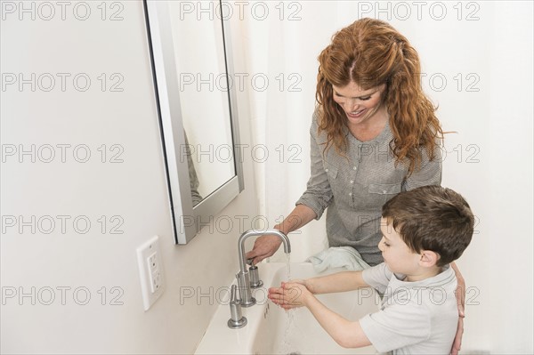 son (6-7) and mother washing hands.