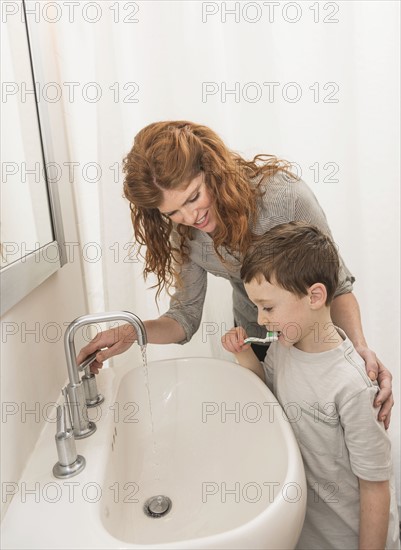 son (6-7) and mother brushing teeth.