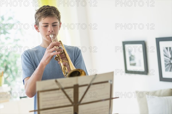 Teenage boy (16-17) playing trumpet.