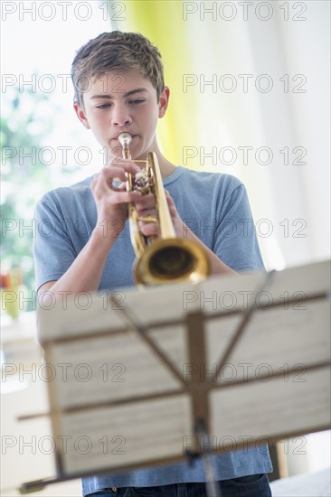 Teenage boy (16-17) playing trumpet.