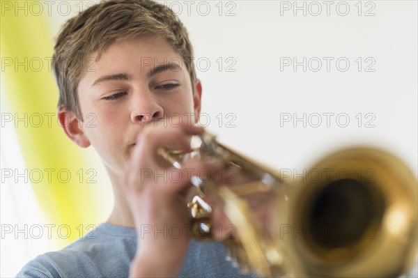 Teenage boy (16-17) playing trumpet.