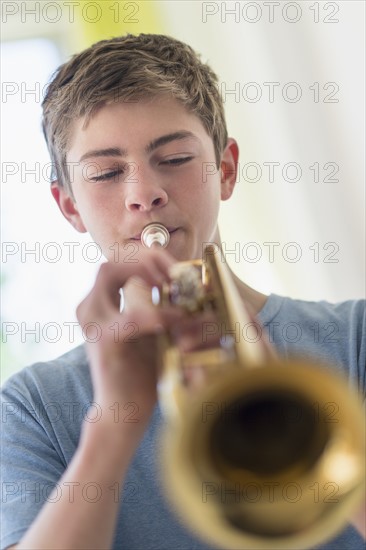 Teenage boy (16-17) playing trumpet.