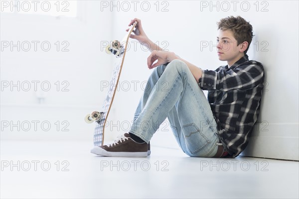 Teenage boy (16-17) holding skateboard.