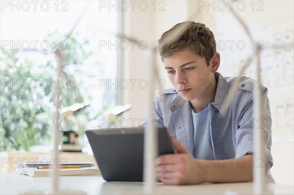 Teenage boy (16-17) using digital tablet in laboratory.