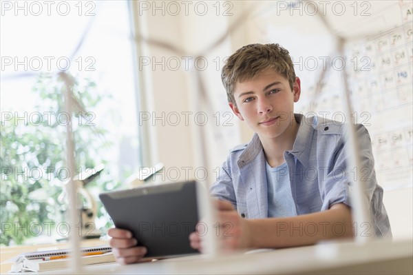 Teenage boy (16-17) using digital tablet in laboratory.