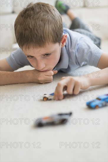 boy (8-9) playing with toy cars.