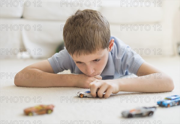 boy (8-9) playing with toy cars.