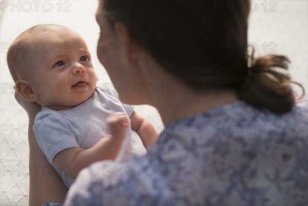 Mother holding baby boy (2-5 months).