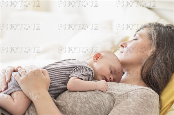 Mother with baby boy (2-5 months) taking nap together.