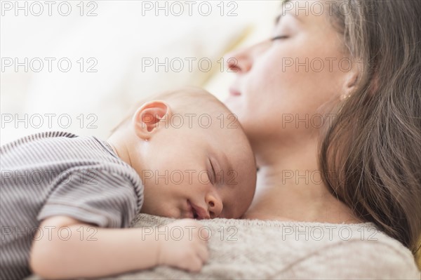 Mother with baby boy (2-5 months) taking nap together.