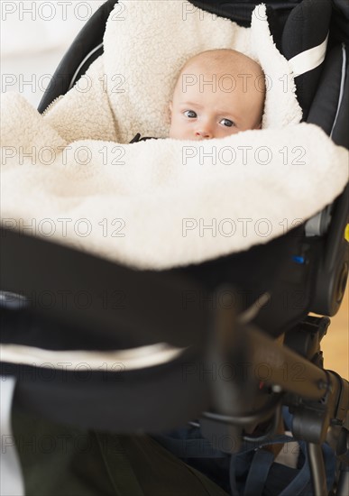 Portrait of baby boy (2-5 months) sitting in stroller.