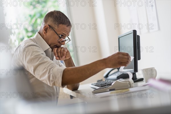 Mature man working in home office.
