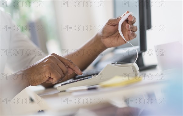 Close up of man's hands using calculator.