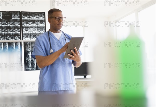 Male doctor in hospital using digital tablet.