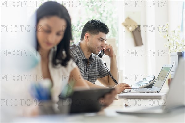 Young man and woman working in office.