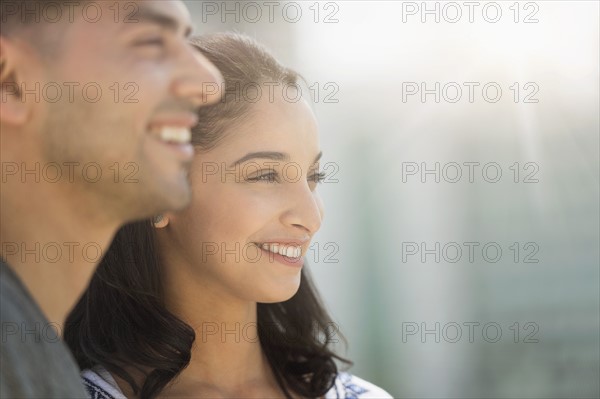 Young couple smiling in sunlight.