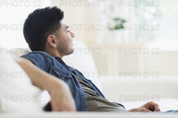 Young man relaxing on sofa.