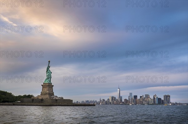 Statue of Liberty with city skyline in background.