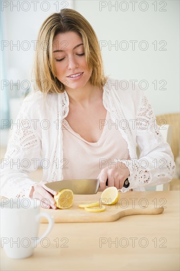 Young woman cutting lemon.
Photo : Jamie Grill