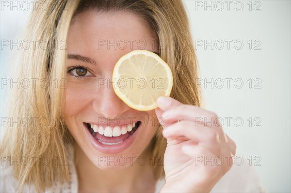 Portrait of young woman holding lemon slice.
Photo : Jamie Grill