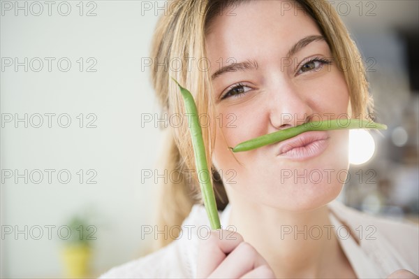 Portrait of blond woman holding green beans.
Photo : Jamie Grill