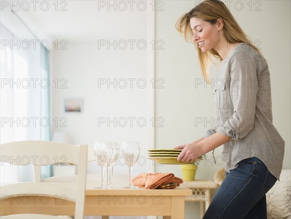 Young woman setting table.
Photo : Jamie Grill