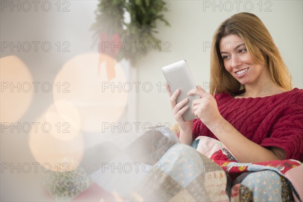 Woman using digital tablet at christmas time.
Photo : Jamie Grill