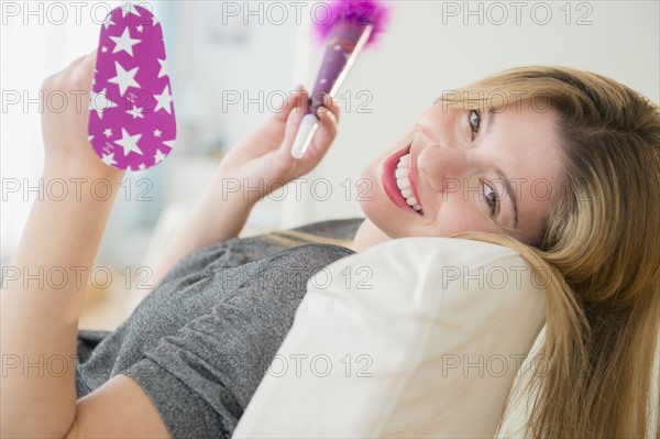 Portrait of young woman holding noisemakers.
Photo : Jamie Grill