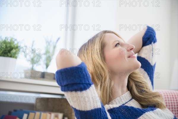 Blond woman daydreaming at home.
Photo : Jamie Grill