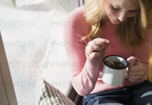 Woman steeping tea in mug.
Photo : Jamie Grill