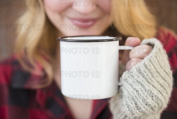 Woman holding metal coffee mug.
Photo : Jamie Grill